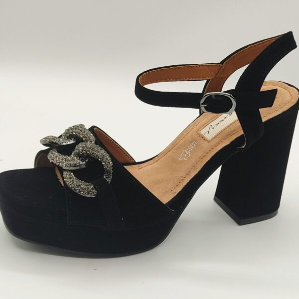 Sandalia de fiesta de la marca MariaMare, modelo 63323 en terciopelo negro. Plataforma y tacón de 10 cm forrados en terciopelo negro. Adorno de una cadena en color plata con incrustaciones de cristales en la parte delantera. Cierre con hebilla al tobillo.