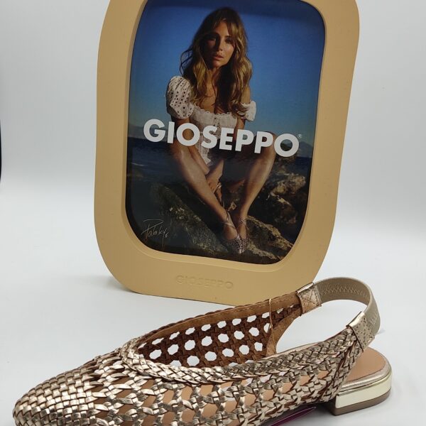 Sandalia para chica de la marca Gioseppo, modelo Guatavita en color oro. Suela plana con tacón dorado de 2 cm. Fabricada en piel trenzada color oro. Elastico dorado rodeando el talón.