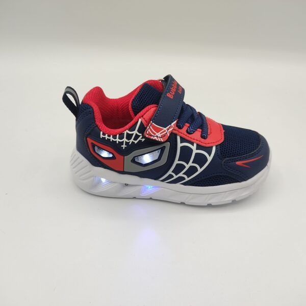 Zapatillas deportivas para niño de la marca Bubble Kids, modelo C1277 en color marino. Suela blanca de poco peso con luces. Fabricada en textil marino con detalles rojos simulando un antifaz con luces en la zona de los ojos y blancos simulando una telaraña. Cierre con cordón elástico y velcro en color marino y rojo.