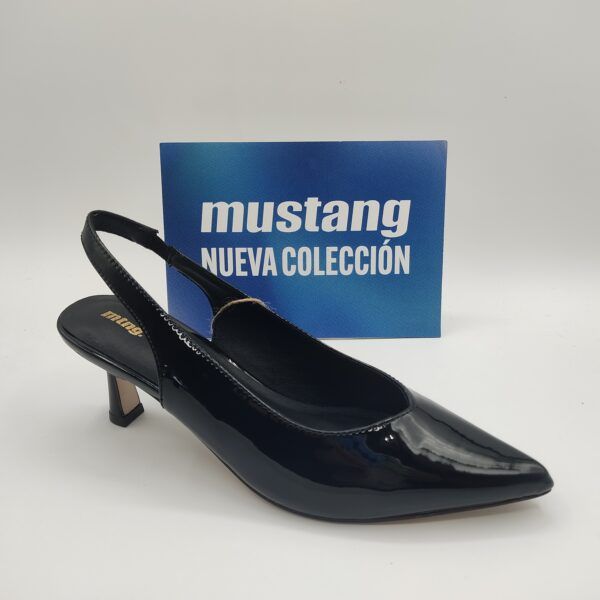 Zapato de tacón para mujer de la marca Mtng, modelo 54163 en charol negro. Tacón fino de 6cm de alto. Correa rodeando el talón con cierre elástico. Punta fina y corte salón terminado en pico.